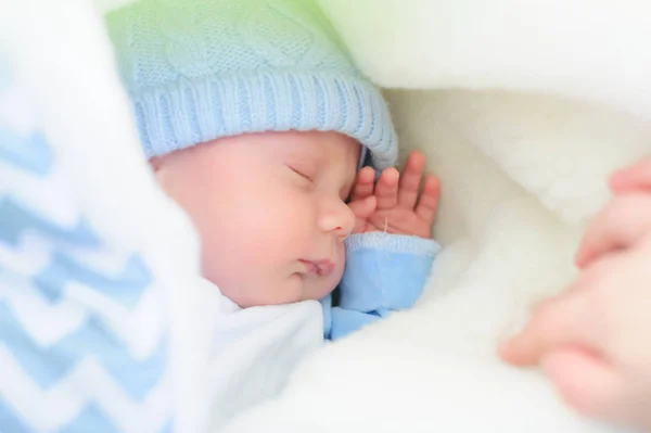 Bedårande liten baby tupplur i ett bo av en filt, klädd i en hårband, närbild — Stockfoto