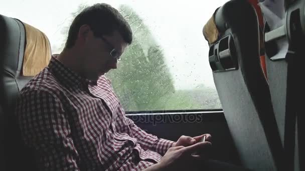 Young man checking emails on his commute to a job by the bus in a long trip. Close-up of using a mobile phone. — Stock Video