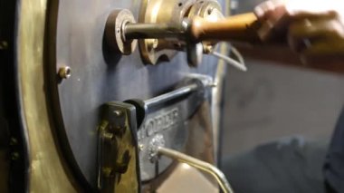 Kahve roastering. Taze kavrulmuş kahve boşaltma ve kavrulmuş kahve karıştırma. Roastering süreci. Yeşil ve kavrulmuş fasulye. Barista. Kafe