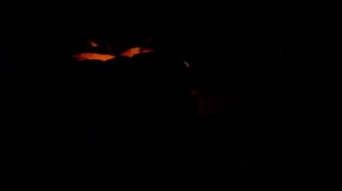 Oyma Halloween balkabağı ışıklar içinde alev yanan mumlar ile siyah bir arka plan ile kapatın. Slowmotion