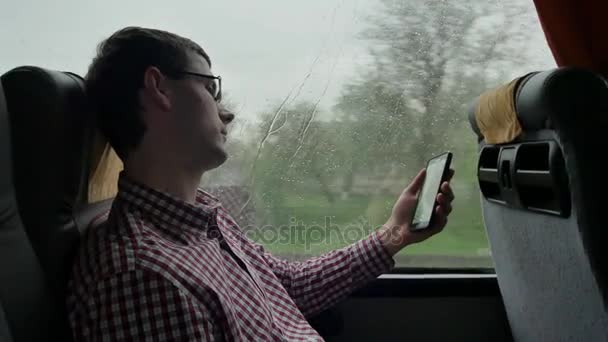 Joven revisando correos electrónicos en su viaje a un trabajo por el autobús en un largo viaje. Primer plano del uso de un teléfono móvil. — Vídeo de stock