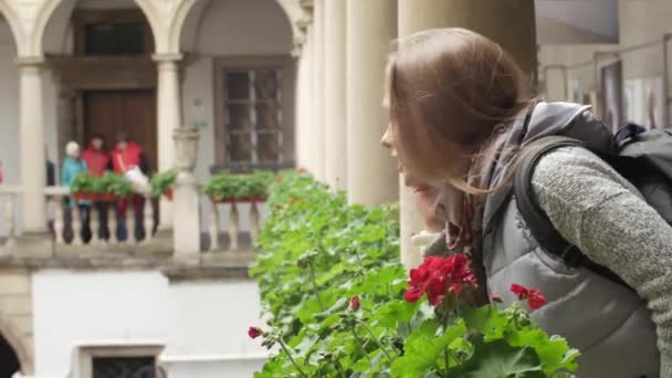 Attraente ragazza bianca sul balcone utilizza un telefono cellulare sul balcone. Sullo sfondo belle colonne medievali — Video Stock