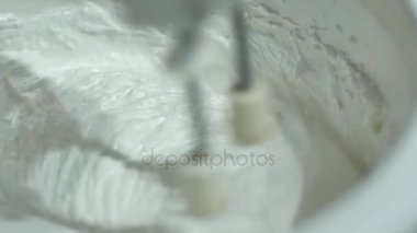 Mutfak robotu beat yumurta beyaz yumurta akı kalın köpük halinde. Mutfak makine operasyonda. Mutfak Mikser kamçı krem kremalı pasta çırpma teli hızla döner.