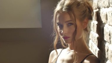 Seksi bir kadın kameraya bakar ve izleyiciyle flört eder. Dudağını ısırır ve nazikçe parmaklarıyla dokunur.