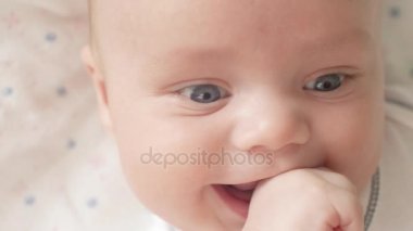 Bebek fotoğraf makinesine yakın çekim yukarı bakışı. Şirin bir bebek kameraya bakıyor. Bebek etrafına bakıyor ve sonra gülümsüyor ve gülüyor. Çocuklar için ebeveyn sevgi bakmakta kavramı ve