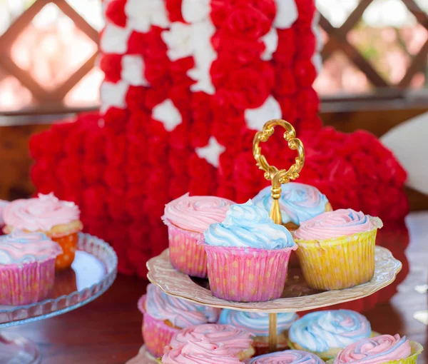 Múltiples muffins coloridos bien decorados sobre un fondo de madera, en las celebraciones de cumpleaños el concepto de hornear en casa y la hospitalidad en casa —  Fotos de Stock