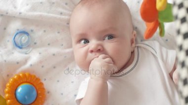 Bebek parmaklar, Closeup emme. 4k atış Ultrahd, Uhd bebek kamera görünümünü kapatın. Şirin bir bebek kameraya bakıyor. Bebek etrafına bakıyor ve sonra gülümsüyor ve gülüyor