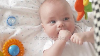 Bebek parmaklar, Closeup emme. 4k atış Ultrahd, Uhd bebek kamera görünümünü kapatın. Şirin bir bebek kameraya bakıyor. Bebek etrafına bakıyor ve sonra gülümsüyor ve gülüyor