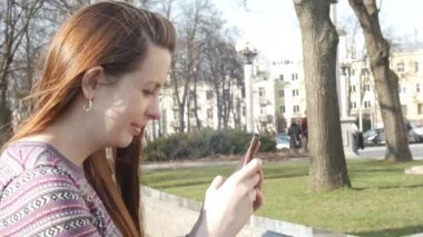 Kadın el dışarıda parkta bankta oturmuş smartphone kullanarak