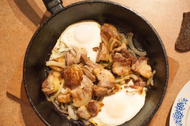 Zengin rustik kahvaltı. Kırsal gıda, kızarmış yumurta domuz eti ve taze sebze bir plaka üzerinde