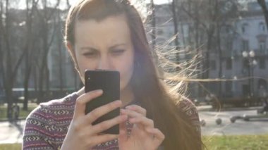 Kız dışarıda parkta bankta oturmuş selfie yapar