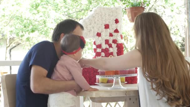 Spegni la candela per il primo compleanno. Mamma padre e bambino prima festa di compleanno — Video Stock