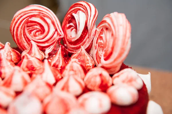 Pastel de terciopelo rojo, decorado con merengues blancos y rojos, fondo blanco, cerca, terciopelo, idea para unas vacaciones, símbolo para la cafetería —  Fotos de Stock