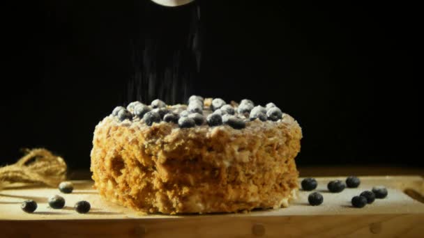 A baker dusting with sugar glaze powder over a delicious decadent puff dessert, topped with blueberries at a slowed pace — Stock Video