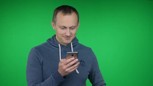 Smartphone, benutzt der junge Mann, lächelt. hromakey — Stockvideo