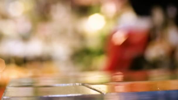 Boule à neige de Noël avec une chouette à l'intérieur secoue et met sur la table une main féminine — Video