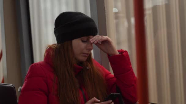 Eine traurige junge Frau tippt während der abendlichen Busfahrt per Handy Nachrichten. defokussierter Stadtverkehr im Busfenster Zeitlupe 4k shot — Stockvideo