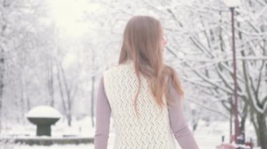 Güzel sarışın kadın kış Park. Kışın mutlu bir kız. O gülümsüyor. Kendisi için arıyor. Ağır çekim. Winter park. Kış orman.