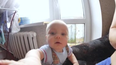 Kameranın Childs'ı görüş atış kapatın. Çocuk objektif yalamak dener. Şirin Bebek kameraya bakıyor. Çocuk görünüyor ve o zaman gülümsüyor ve gülüyor. Çocuk Bakımı kavramı