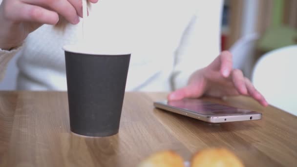 Щаслива біла ділова жінка, жінка в міському кафе, дівчина, тримає смартфон в руці і використовує мобільний смартфон з чашкою кави, концепція спілкування нові інтернет-технології повільно — стокове відео