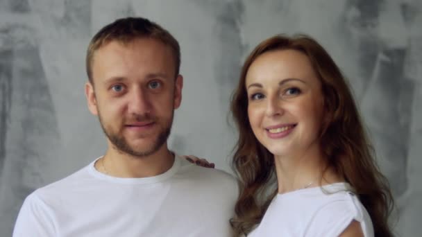 Junges Ehepaar, Mann und Frau posieren vor der Kamera. das Mädchen beginnt zu lachen — Stockvideo