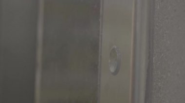 Kadın ya da erkek ofis ya da apartman koridorunda asansör çağırmak için düğmeye basıyor. 4k ağır çekim videosunu kapat.