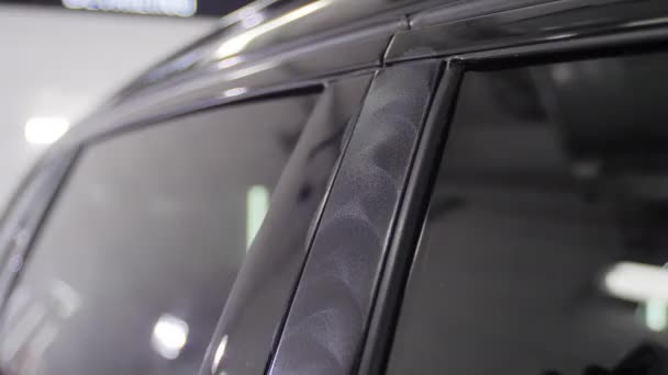 Bricoleur est le polissage d'une porte de voiture noire supports avec un équipement spécial épilation à la cire dans une station-service de voiture. 4K ralenti gros plan vidéo . — Video