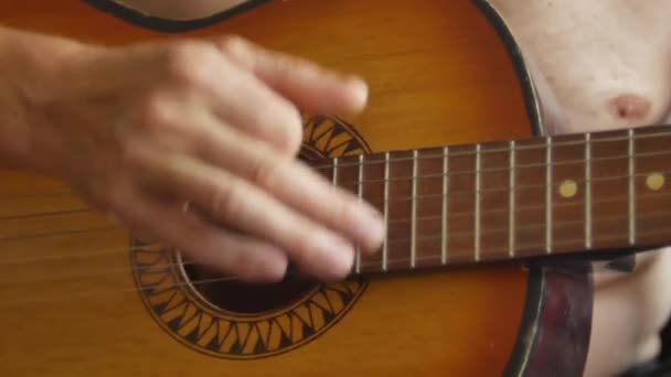 Un hombre está tocando una guitarra acústica de seis cuerdas vintage. Vista frontal de cerca en video 4K . — Vídeos de Stock