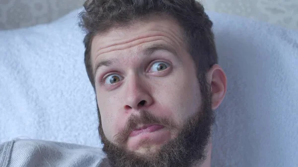 A young bearded man poses a face showing tongue hamming smiling and laughing closeup — Stock Photo, Image