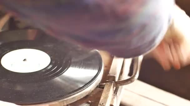 Person puts a record on an old gramophone. Turns it on with a special handle. Vintage interior items. — Stock Video