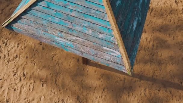 Drone décolle au-dessus d'un parasol en bois, debout à la plage sur le lac, puis la caméra se tourne vers le lac et le ciel bleu ensoleillé avec des nuages se reflétant dans l'eau. Vue aérienne Vidéo 4K . — Video