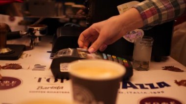 Bir müşteri, kahve makinesinde kahvecinin yaptığı kahveye plastik kartla ödeme yapıyor. Kafe 4k yavaş çekimde, videoyu kapat.