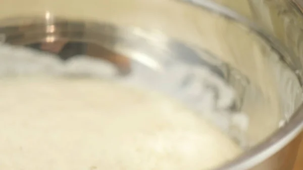 Impastare la panna bianca in una ciotola di vetro profonda per cuocere una torta. Close up vista frontale rallentatore 4K video . — Foto Stock