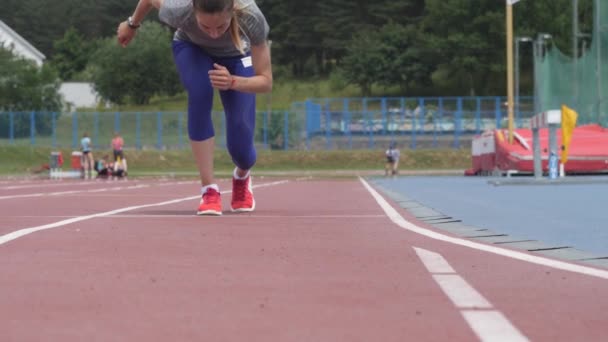 Mladá krásná žena sportovec začíná běžet ve atletického oválu v den tréninku v pomalém pohybu videa 4k Uhd kamerou — Stock video