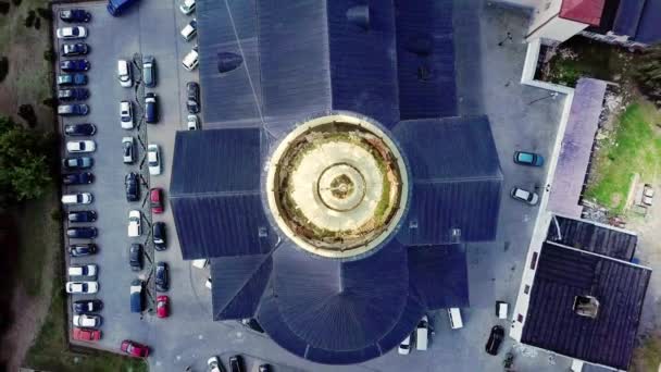 A câmera descola verticalmente acima da cúpula dourada da catedral com um teto preto e abre uma vista superior sobre os telhados dos edifícios históricos vizinhos da cidade. Drone vista tiro em 4K . — Vídeo de Stock