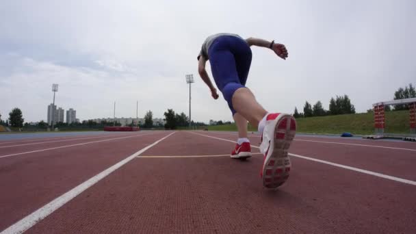 Uma bela jogger mulher começa a correr no estádio de atletismo da cidade durante um dia de treinamento em câmera de lente larga 4K em câmera lenta — Vídeo de Stock