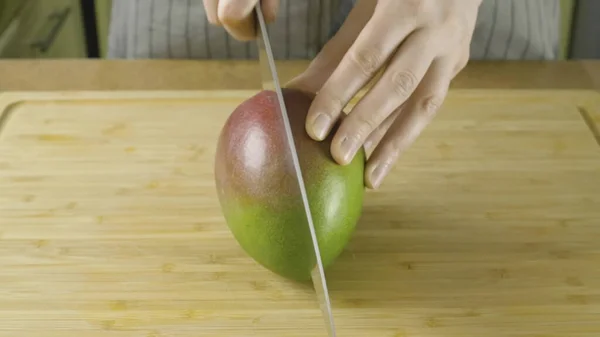 Kadın eller 4k yakın çekim video parçaları taze sarı Mango tarafından kesilmiş ortaya çıkmış