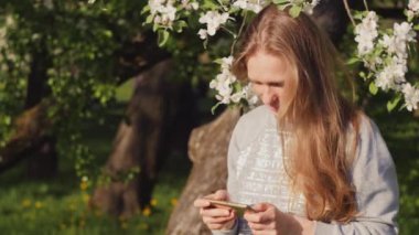 Güzel beyaz kız telefondaki fotoğrafa bakıyor.