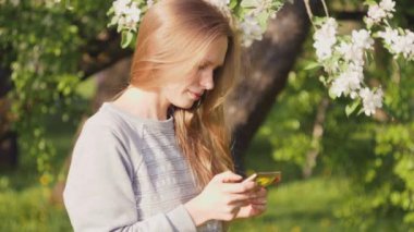 Güzel beyaz kız telefondaki fotoğrafa bakıyor..