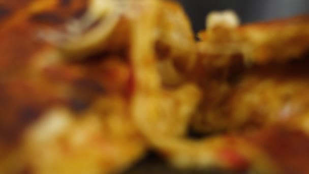 Primer plano de la mano del chef tomando un delicioso pedazo de pizza con salami encurtidos queso en una tabla de madera . — Vídeo de stock