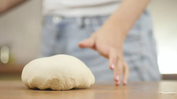 Mujer en la mesa de la cocina hace pizza de comida doméstica, manos de trabajo y empujando agitar amasar la masa, enfoque selectivo dolly shot —  Fotos de Stock