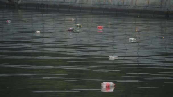 Çevre kirliliği. Çöpler şehirdeki bir nehirde yüzüyor. İnsan sorumsuzluğu. — Stok video