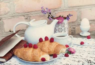  Kruvasan kahve ve ahududu üzerinde beyaz dantel masa örtüsü