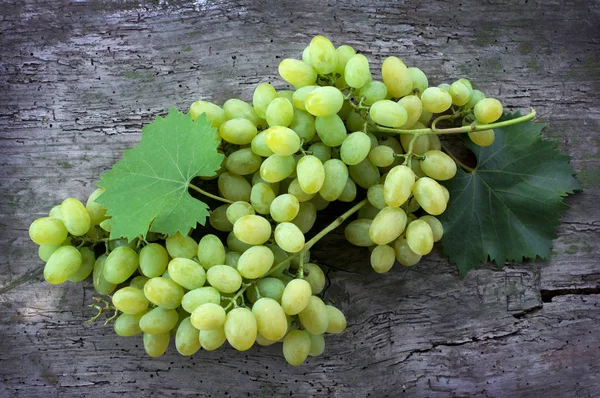 Aglomerados de uvas verdes maduras sobre fundo de madeira — Fotografia de Stock
