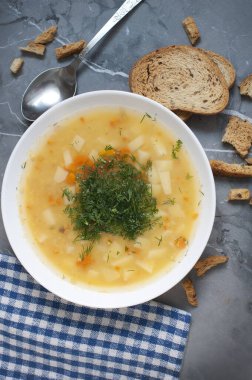 Dereotlu bezelye çorbası, koyu gri arka planda ızgara ve kırıntılar. Üst görünüm