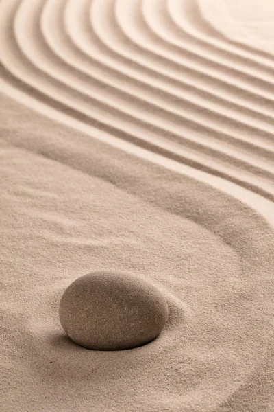 zen meditation stone on sand