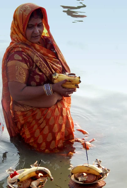ヒンドゥ教徒の女性は2017年10月27日にインドのハイデラバードで行われた毎年恒例のチャブ法会で 湖のほとりで夕暮れ時に太陽神を祈るための食べ物を提供しています — ストック写真
