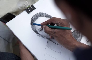 Hintli bir sanatçı, Hindistan 'ın Hyderabad şehrinde 15 Şubat 2020' de halka açık bir yerde Hintli bir kadının kalem portresini çizdi.                             