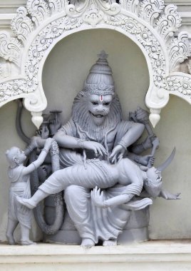 Hindu tanrısı Narasimha heykeli, Vishnu avatarı, tapınak duvarında kötü bir adamı cezalandırıyor.           