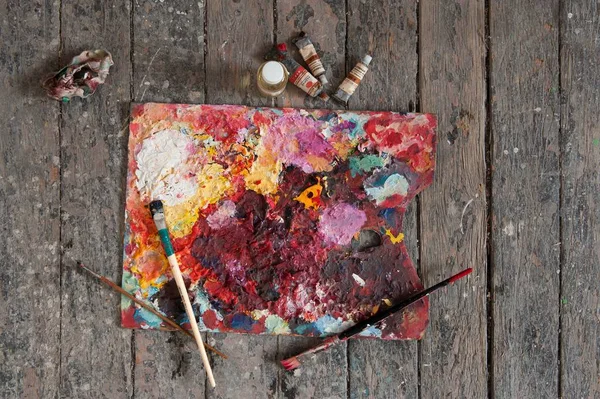 Palette, tubes of oil paint and artist paint brushes